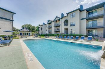Swimming pool with lounge chairs and balcony views